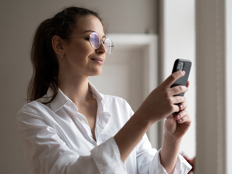 makes-selfie-phone-portrait-brunette-woman-with-glasses-white-shirt
